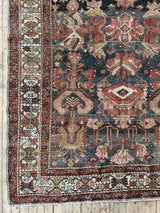 Hand-knotted vintage Persian rug with intricate patterns on a wooden floor
