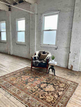 Hand-knotted vintage Persian rug in a living room with armchair, sheepskin, and side table