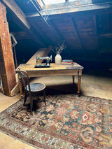 Hand-knotted vintage Persian rug in home office with wooden desk and skylight