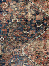 Close-up of a hand-knotted antique Persian Afshar area rug with medallions and an allover animal motif