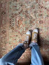 Person with yellow shoes on a hand-knotted antique Persian Mahal area rug with allover botanical motifs on a celadon green field