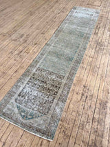 Vintage runner rug with a boteh pattern on a wooden floor