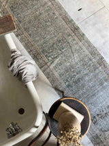 Bathroom setting with a bathtub, towel, and vintage runner rug