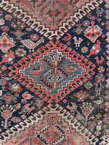 Close-up of aVintage Persian rug with colorful medallions and animal motifs