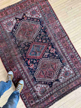 Person standing on a Vintage Persian rug with colorful medallions