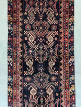 close-up of a vintage Persian Hamadan runner rug with brick red and peach herati motif and navy blue field