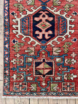 Vintage Persian accent rug on a wood floor