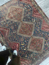 Antique hand-knotted Persian area rug with a geometric medallion pattern, featuring a bird motif