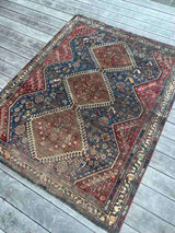Antique hand-knotted Persian area rug with a geometric medallion pattern, featuring a bird motif