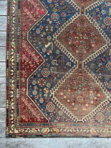 Antique hand-knotted area rug with a geometric medallion pattern, featuring a bird motif