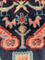 Close-up of Vintage Caucasian Kuba accent rug with animal motifs and navy field