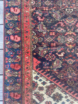 close-up of the border of an Antique Persian area rug with an allover motif on navy field