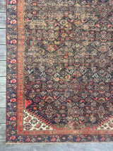 Corner of an Antique Persian area rug with an allover motif on navy field