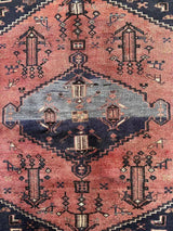 Close-up of a Vintage Persian Saveh area rug with dusty pink and blue medallions and a navy field