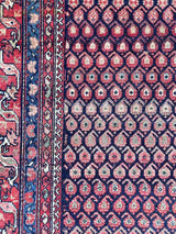 çlose-up of an Antique Persian area rug with multi-colored boteh motifs