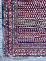 Close-up of an Antique Persian area rug with boteh motifs