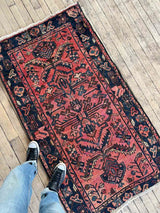 Person standing on a Vintage Persian area rug botanical motifs