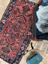 Vintage Persian area rug botanical motifs with a chair and sheepskin