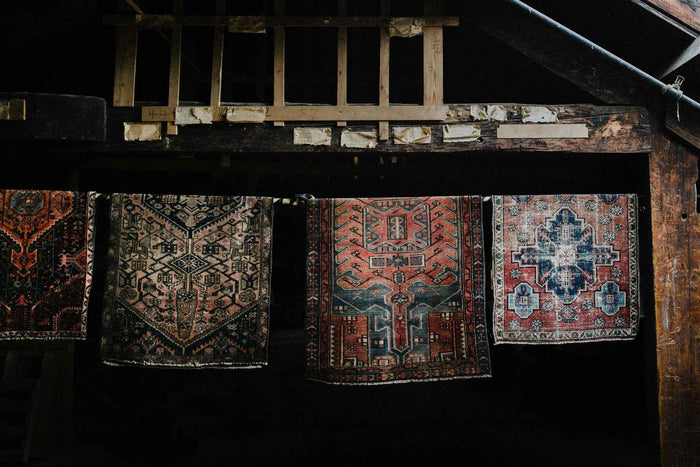 farmhouse bathroom with clawfoot tub and vintage rug from Woven Kin Home