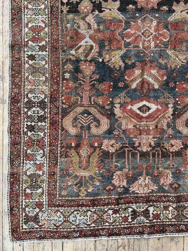 Hand-knotted vintage Persian rug with intricate patterns on a wooden floor