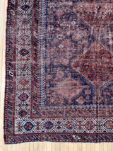 Hand-knotted antique Persian Afshar area rug on a wood floor