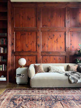 Library with a beige sofa and a hand-knotted antique Persian Afshar area rug 