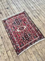 Vintage Persian Karajah rug with colorful medallions and a red background