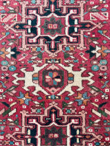 Close-up of a Persian Karajah rug with intricate designs on a red background
